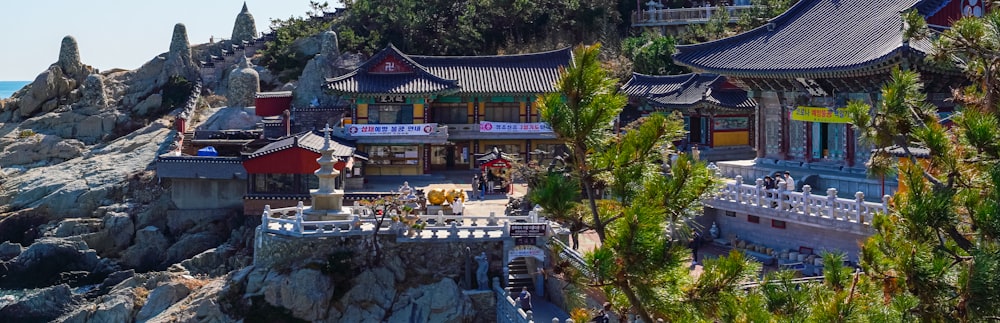 a group of buildings with trees and rocks in front of them