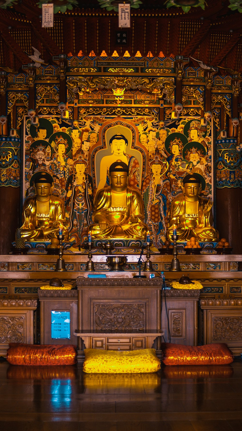 a group of gold statues in a room with a wall of colorful walls