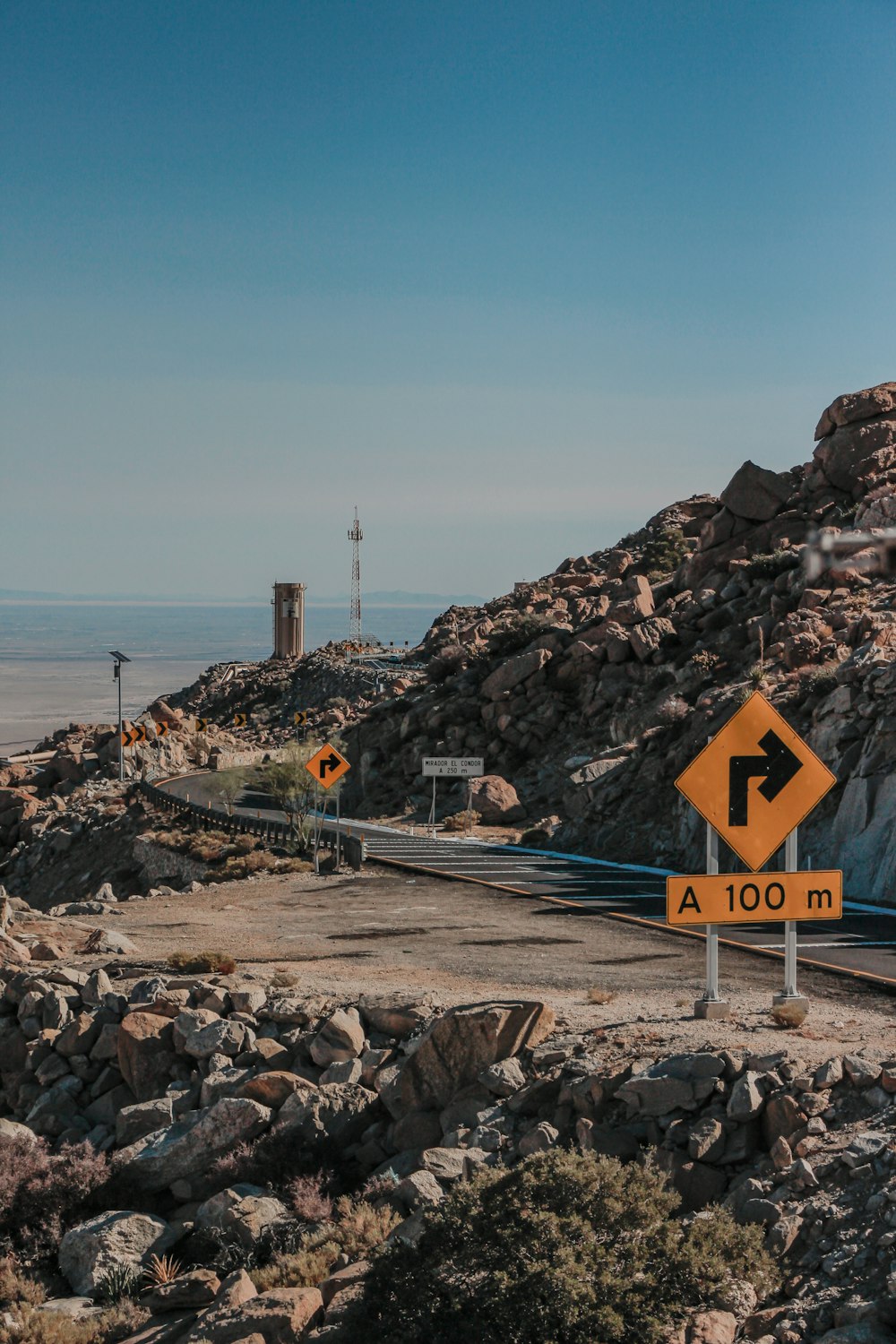 a road with signs on it by a rocky beach