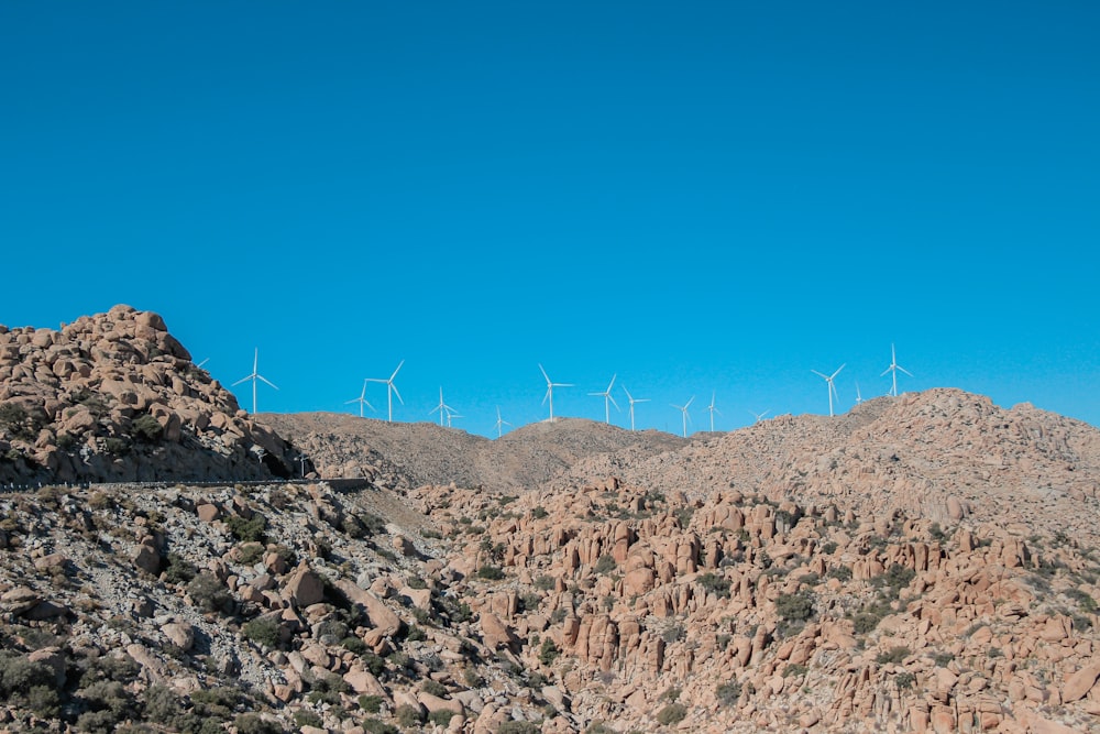 a rocky hillside with wind turbines