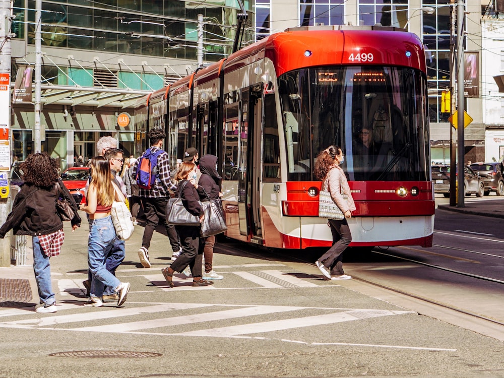 a group of people walking on the sidewalk next to a bus