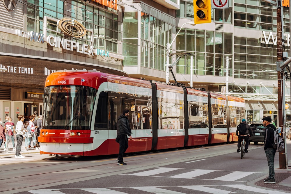 un chariot rouge et blanc dans une rue avec des gens marchant sur le trottoir