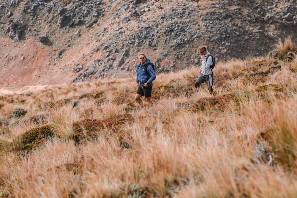 two people walking in a grassy area