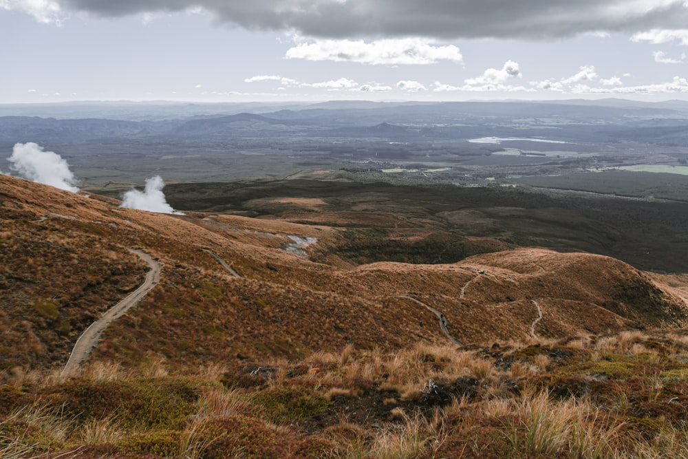 a landscape with a road and a body of water in the distance