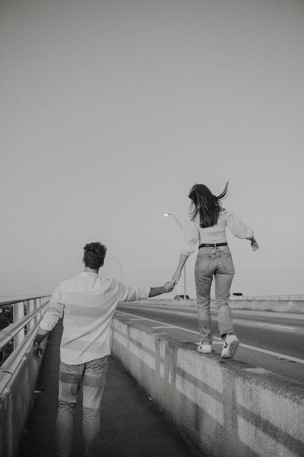 a man and a woman walking on a bridge