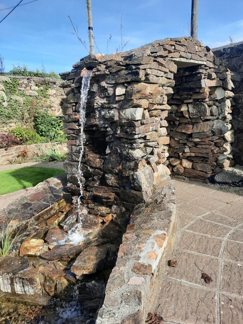 a water fall with a stone wall