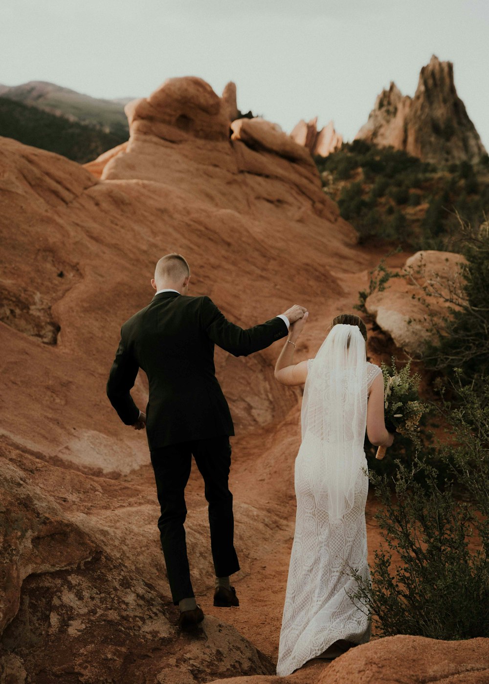 a man and woman walking on a rocky path