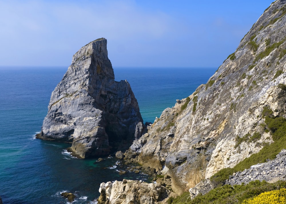 a rocky cliff next to the ocean