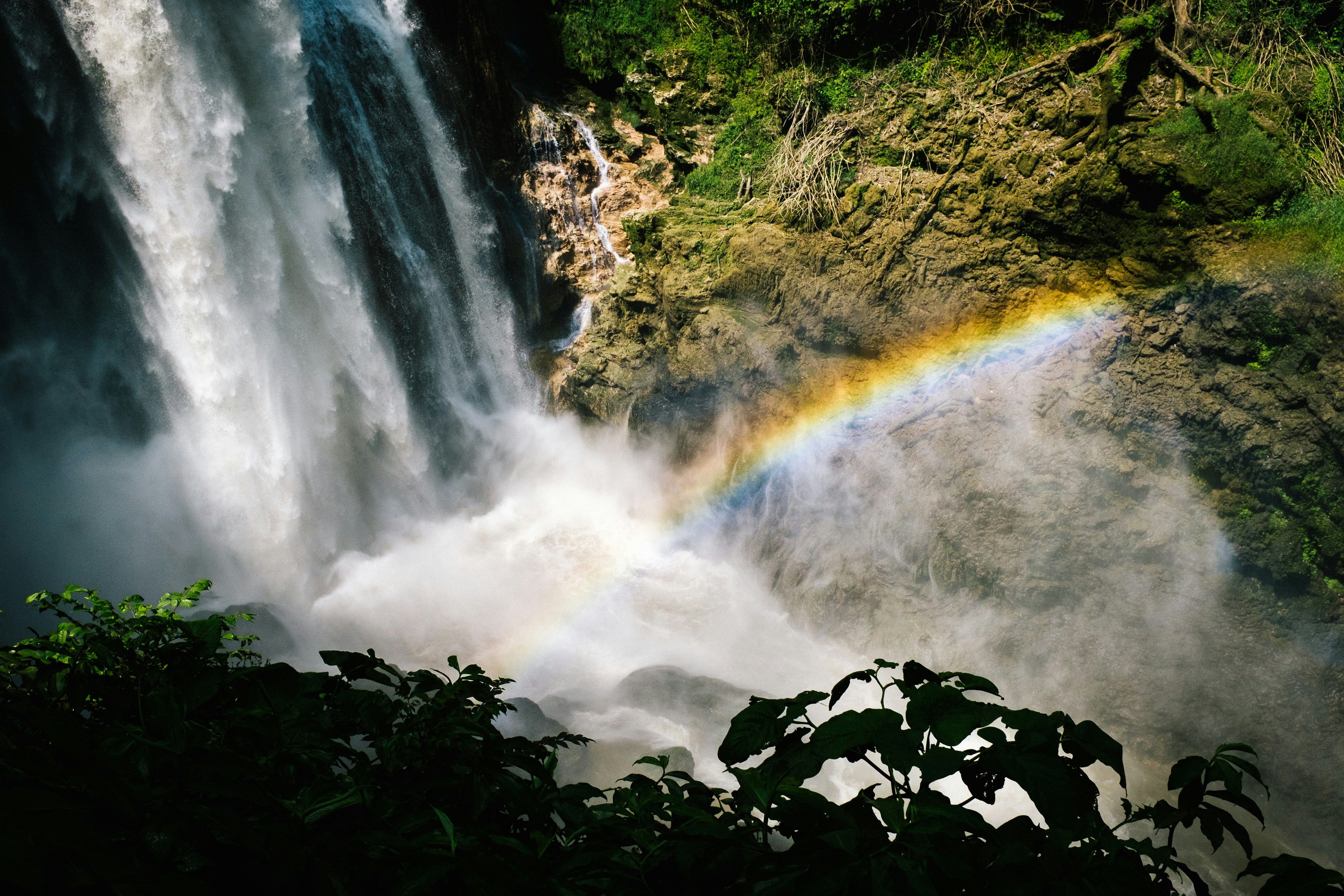 a waterfall with a rainbow