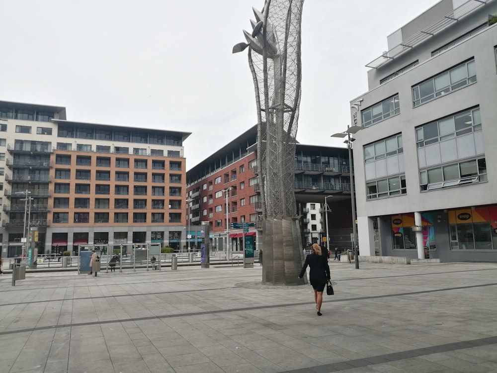 a person walking in a courtyard with buildings in the background