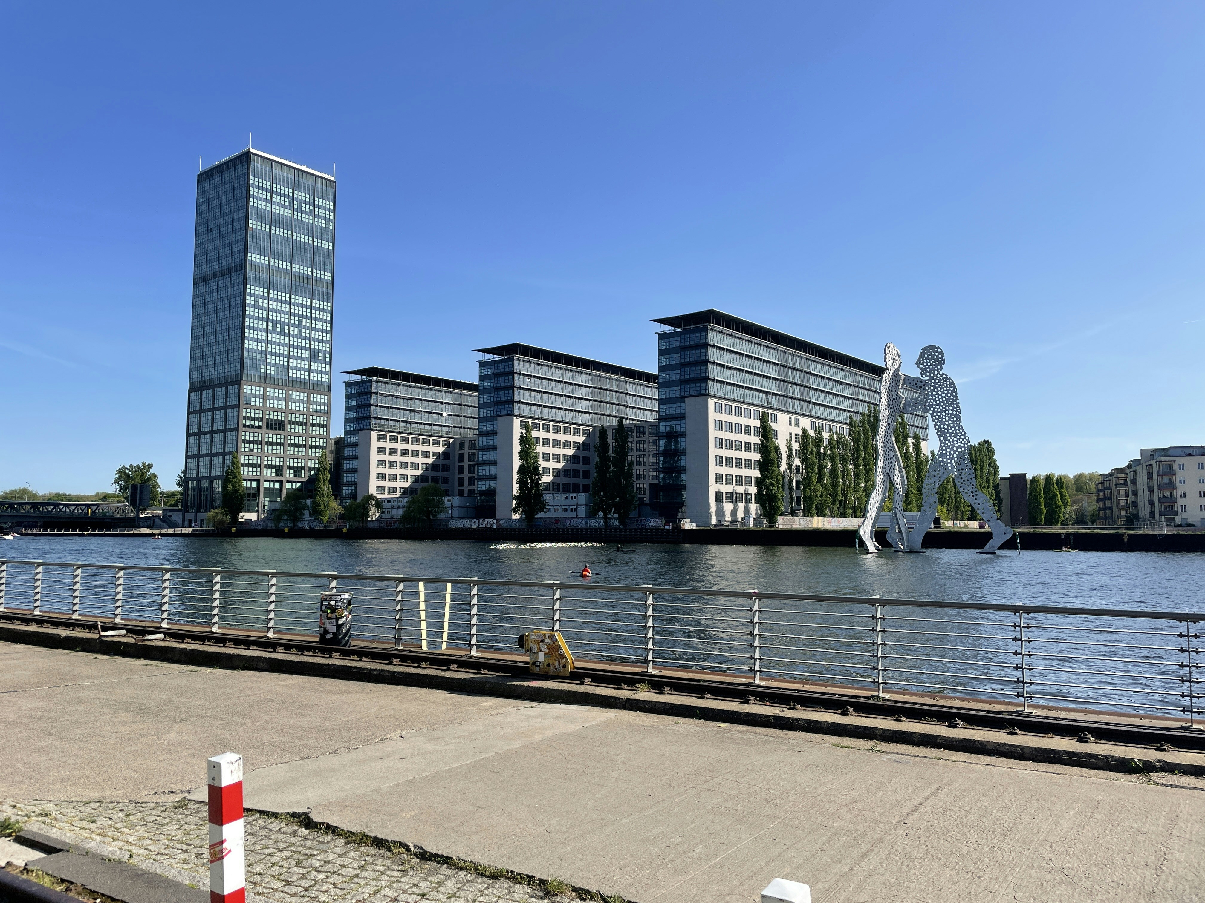 a body of water with a fountain and buildings in the background