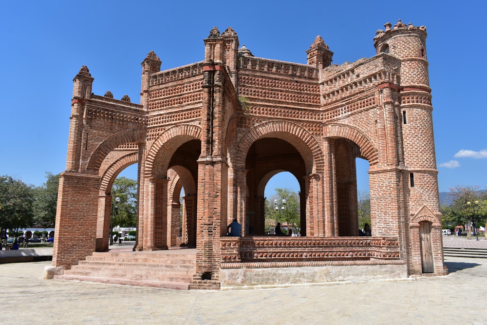 a large stone building with Arc de Triomf in the background