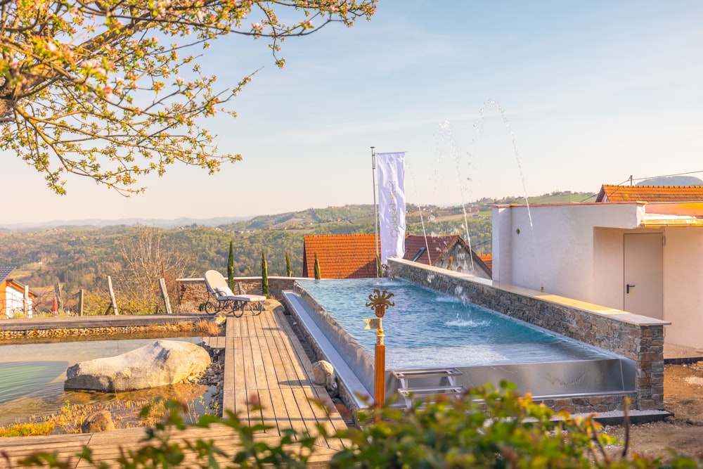 a swimming pool with a deck and trees in the background