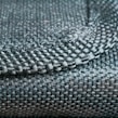 Close-up of a finely textured fabric from a ja wears by as jacket, highlighting craftsmanship.