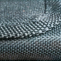 Close-up of delicate handloom fabric textures in deep green and cream, highlighting artisanal craftsmanship.