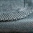 A close-up view of a woven fabric showcasing a detailed pattern and texture with tightly interlaced fibers. The image focuses on the intersection of different textile strands, highlighting the intricate craftsmanship.