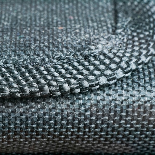 Close-up of a finely woven fabric showcasing intricate Indian craftsmanship in natural light.