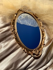 A golden mirror tray on gold silk.