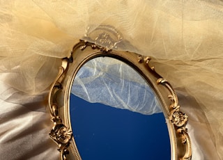 A golden mirror tray on gold silk.