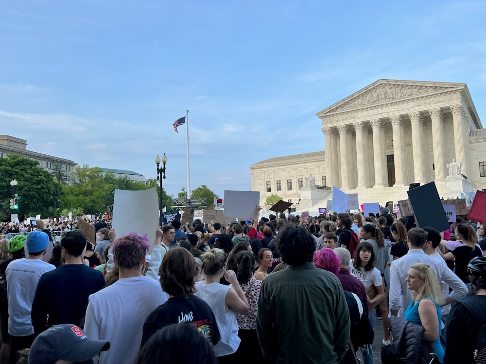 a crowd of people in front of a white building