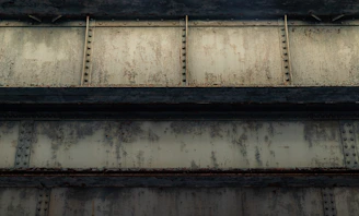 Close-up of handheld laser cleaning device gently removing rust from steel beam on a construction site.