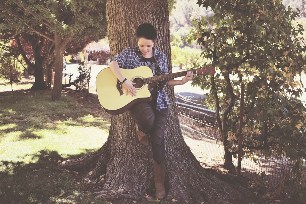 a man playing a guitar in a tree