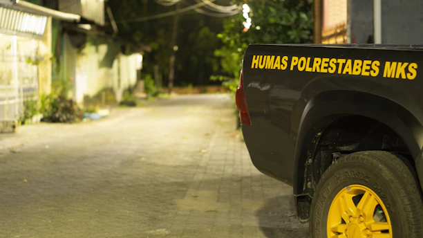 A sturdy tow truck from vėjas keltas parked on a quiet street at sunset.