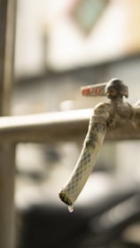 Close-up of a plumber tightening a faucet handle with a wrench.