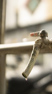 Close-up of hands repairing a leaky faucet with a wrench.