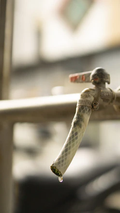 Close-up of a plumber tightening a faucet handle with a wrench in a cozy kitchen.