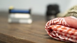 Close-up of folded industrial wiping rags on a wooden workbench.
