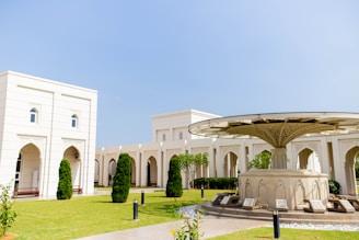 a white building with a green lawn
