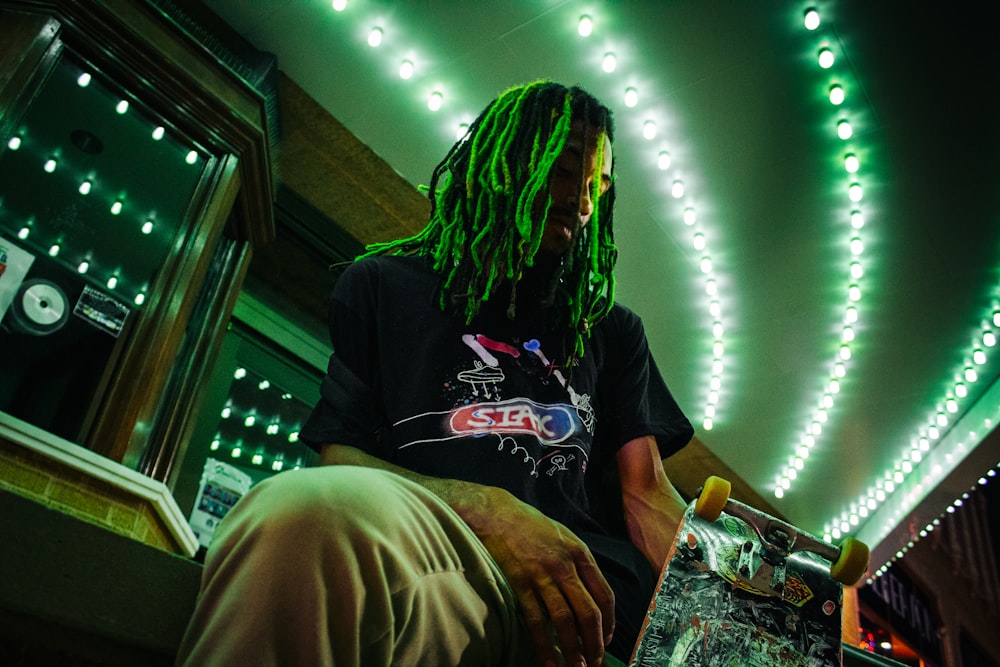 a man with long hair sitting in a chair in a dark room