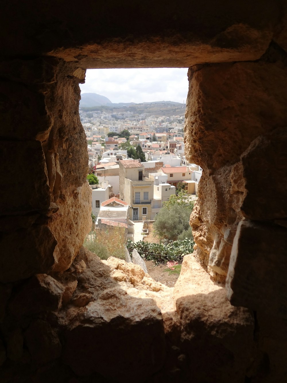 Una vista di una città da una finestra in un edificio in pietra