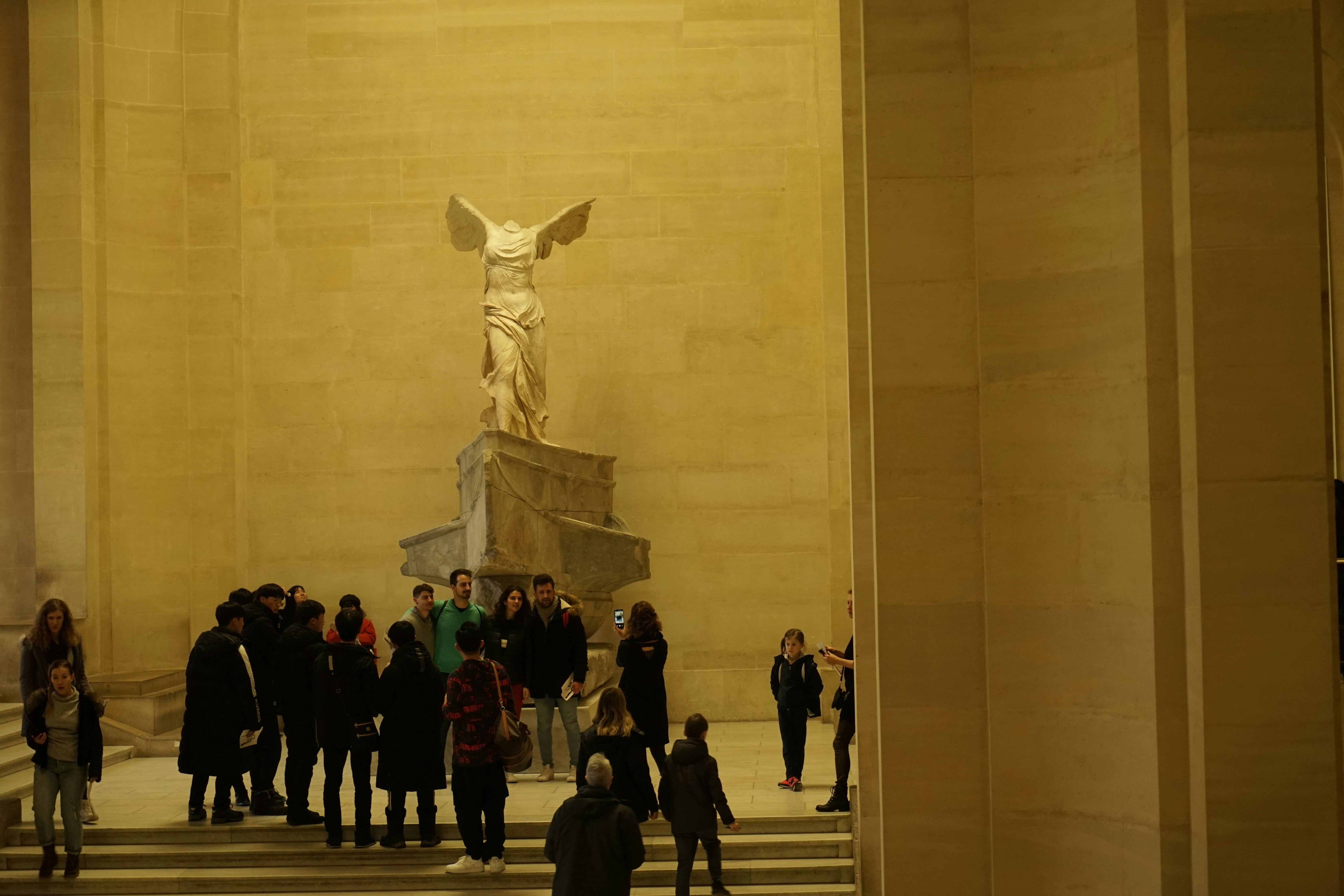 a group of people standing in front of a statue