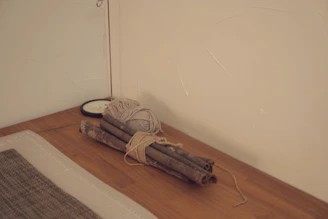Bundles of cinnamon sticks tied with natural fiber twine resting on a woven mat.