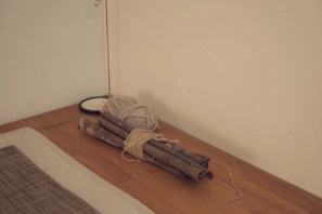 Bundles of cinnamon sticks tied with natural fiber twine resting on a woven mat.
