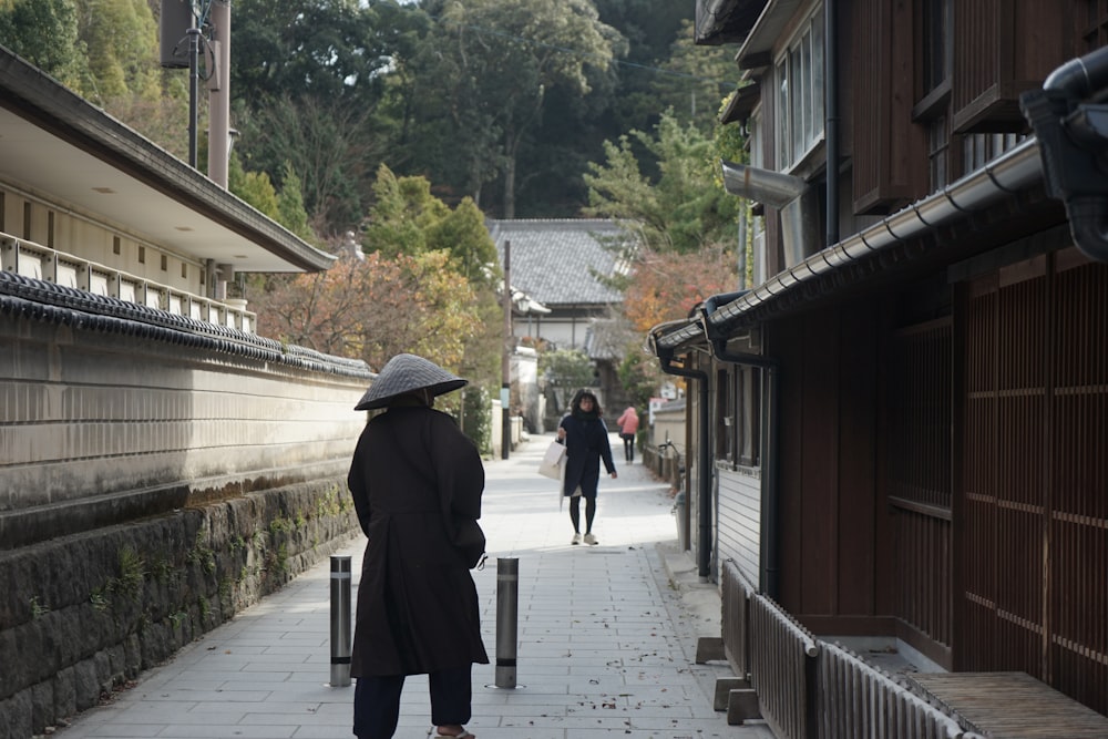 a group of people walking on a stone path between buildings