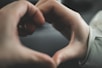 A close-up of hands holding a heart symbol, symbolizing care and protection.