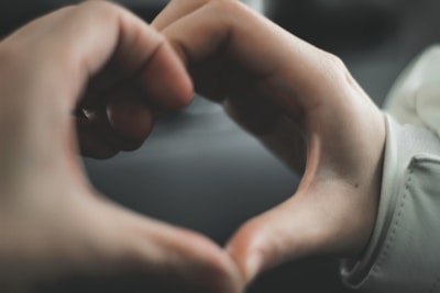 Close-up of hands forming a heart shape symbolizing connection and support.