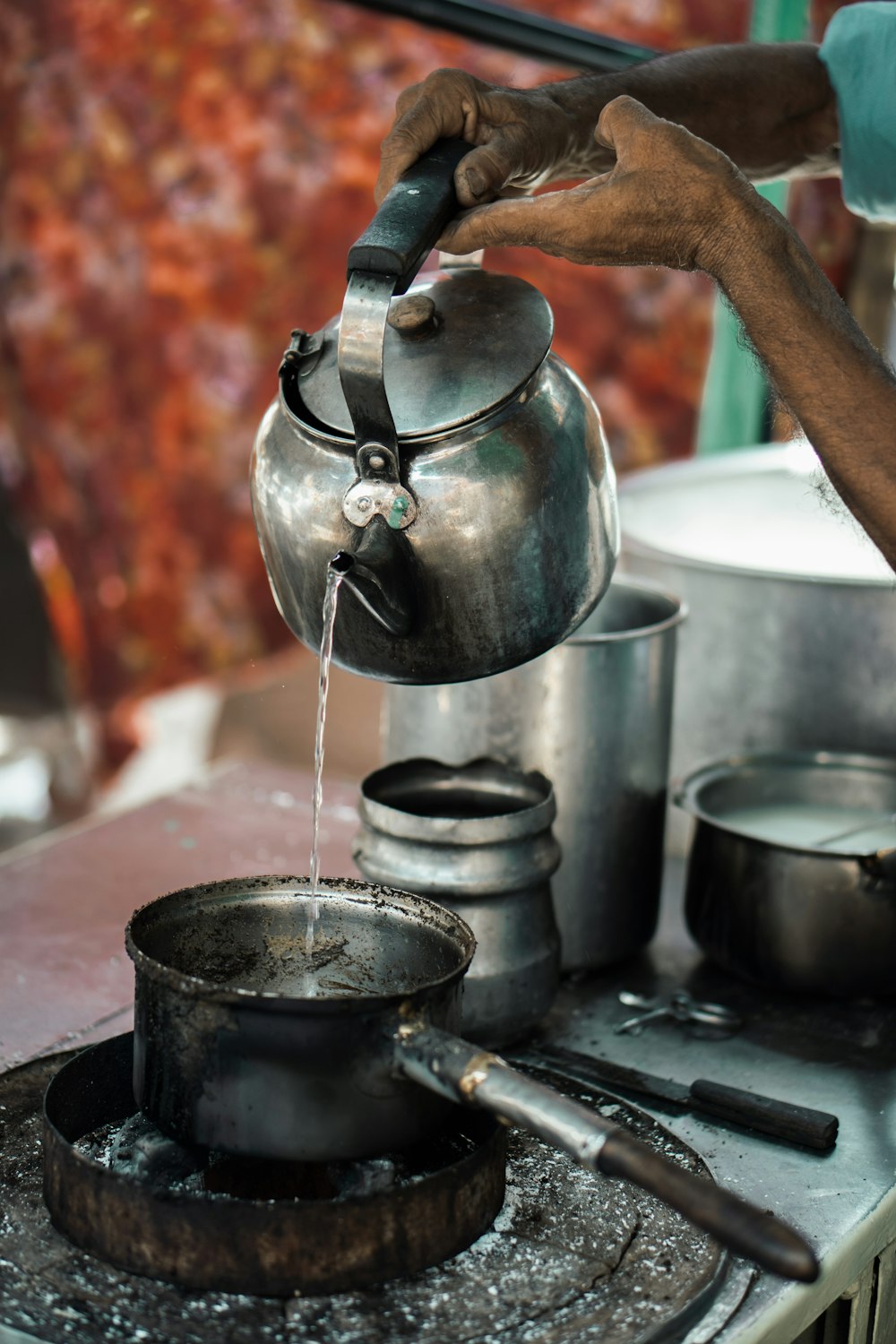 a person pouring water into a pot