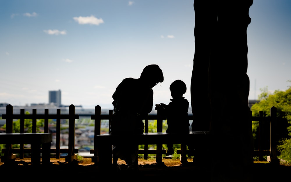 a person and a child sitting on a bench