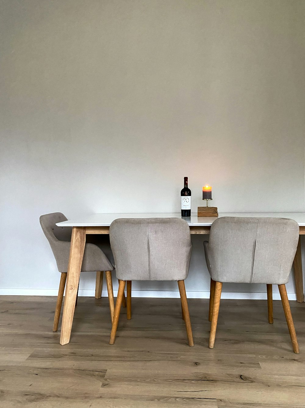 a table with chairs and a bottle of wine on it