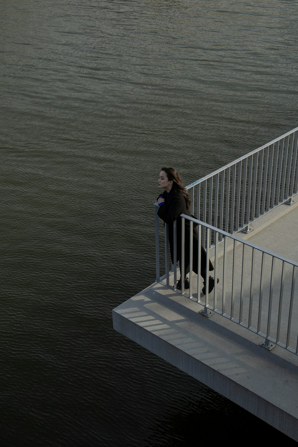 a person standing on a bridge over water