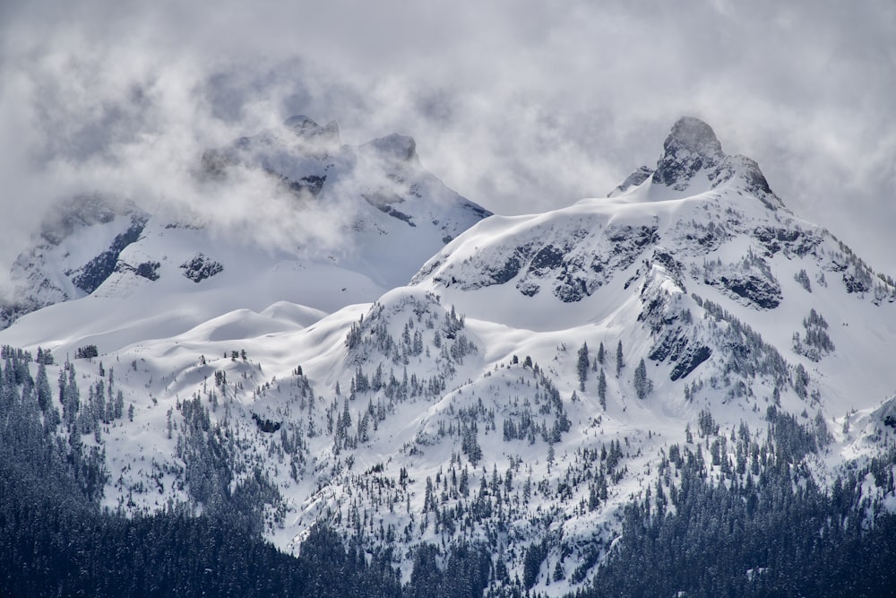 a snowy mountain with clouds