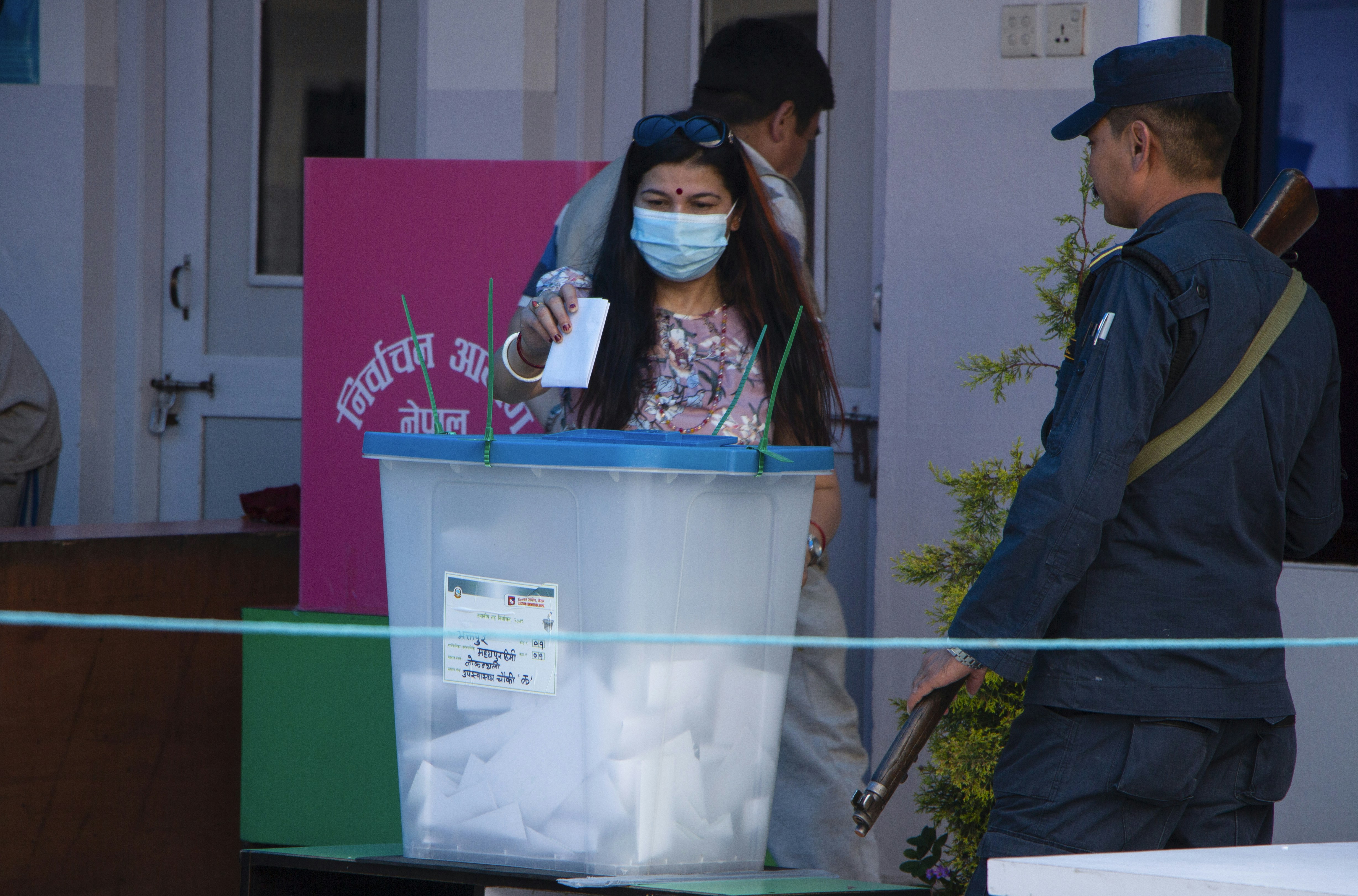 a woman in a mask and a man in a mask behind a podium