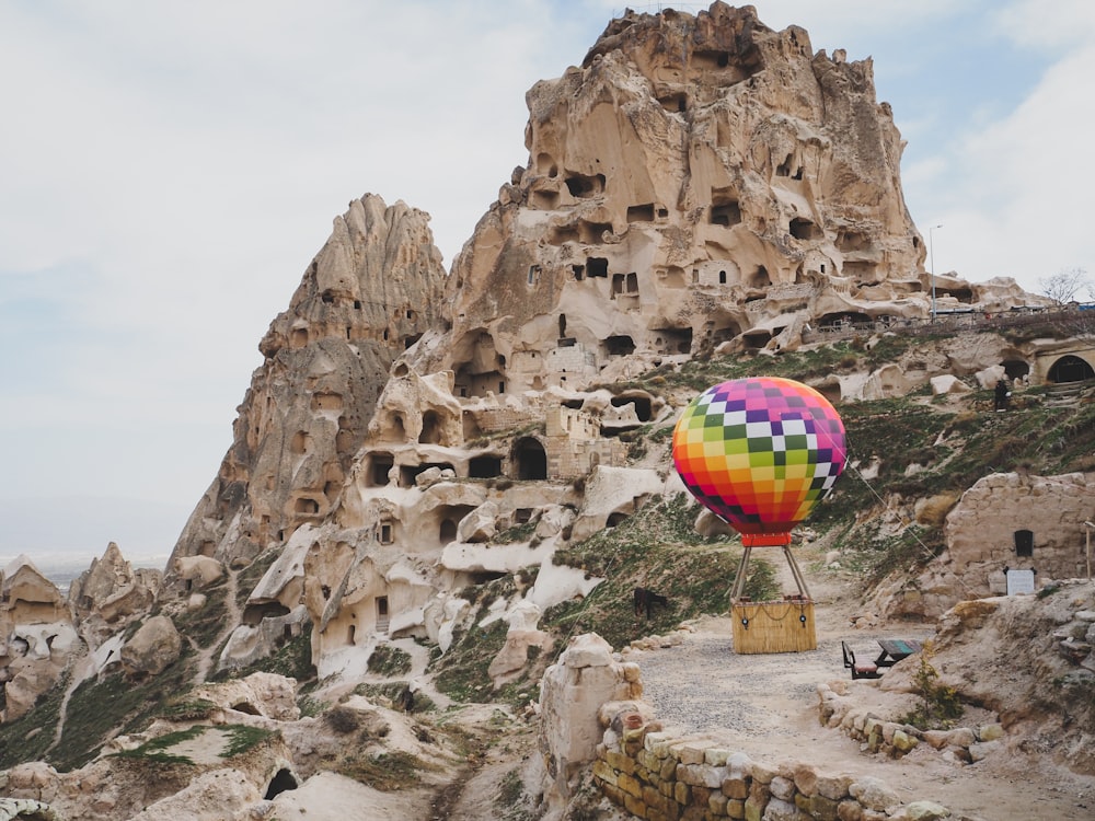 a hot air balloon flying over a rocky mountain