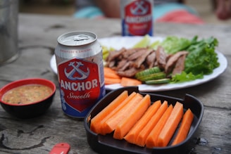 The Hungry Traveller: Food Adventures in Cambodia a plate of food and a can of beer