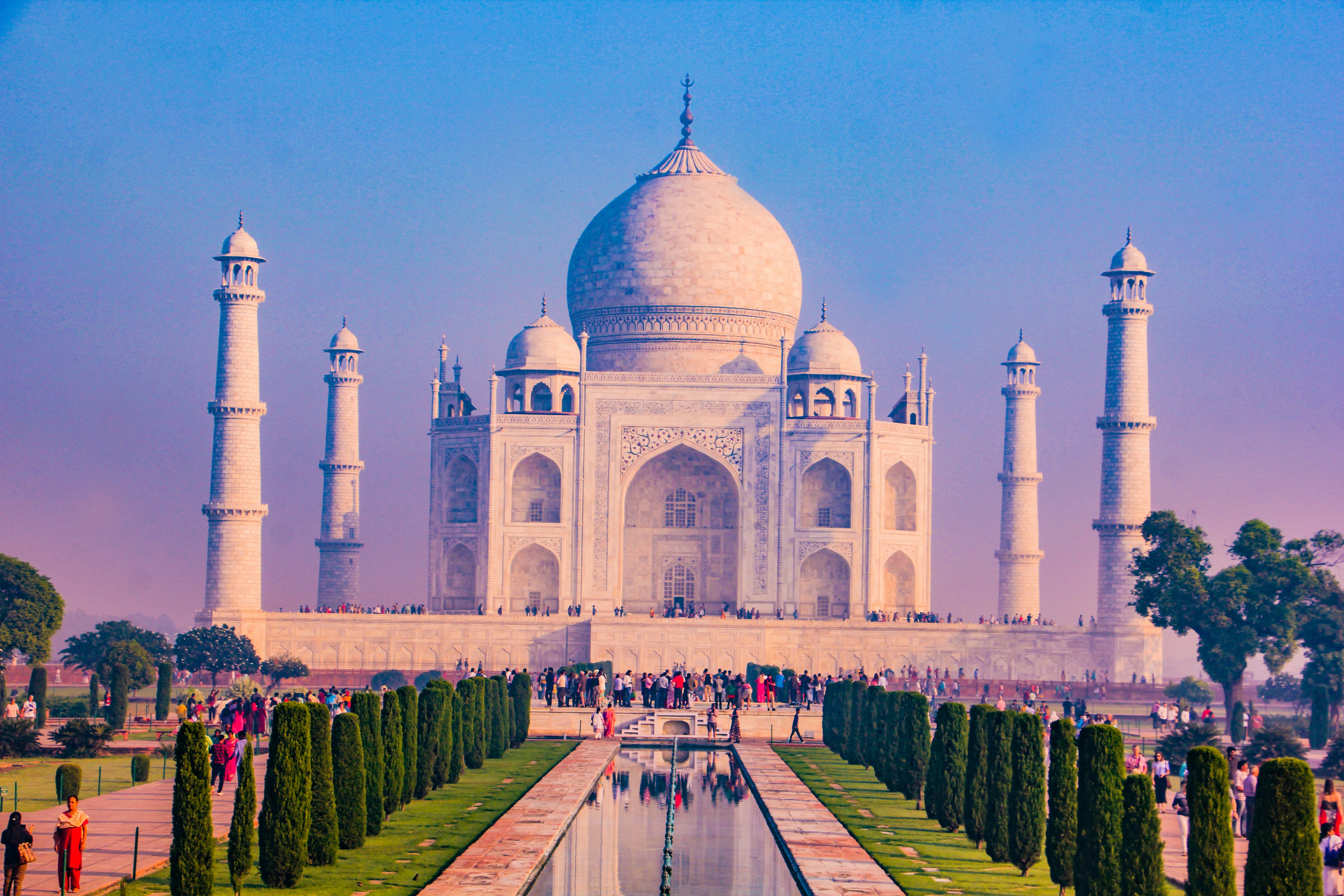 a large white building with a dome and towers with Taj Mahal in the background, 
