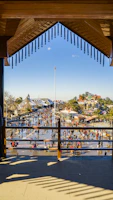Twilight scene of a lively plaza filled with people enjoying outdoor dining and street performances.